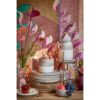 Gestylede tafelopstelling met Ozzu servies, bloemen en fruit op een dressoir
