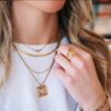 Slangenketting met hartje gedragen met andere gouden kettingen