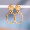 Statement oorbellen met muntje en ovale hanger in goud