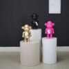 Aap beeldjes The Legend in goud, zwart en roze op witte zuilen