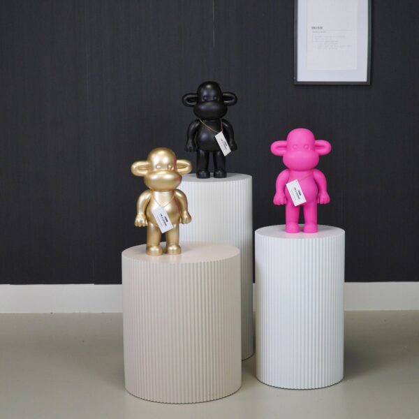 Aap beeldjes The Legend in goud, zwart en roze op witte zuilen