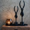 Tasman XS dark taupe waxinelichthouder met kaarsje naast decoratieve beelden