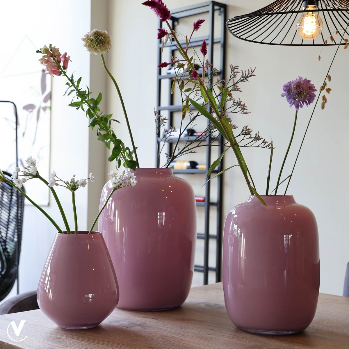 Artic-vazen in roze tinten met bloemen op een eettafel