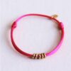 Satijnen armband met ringen in fuchsia en goud