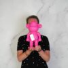 Aap beeldje roze in de handen gehouden