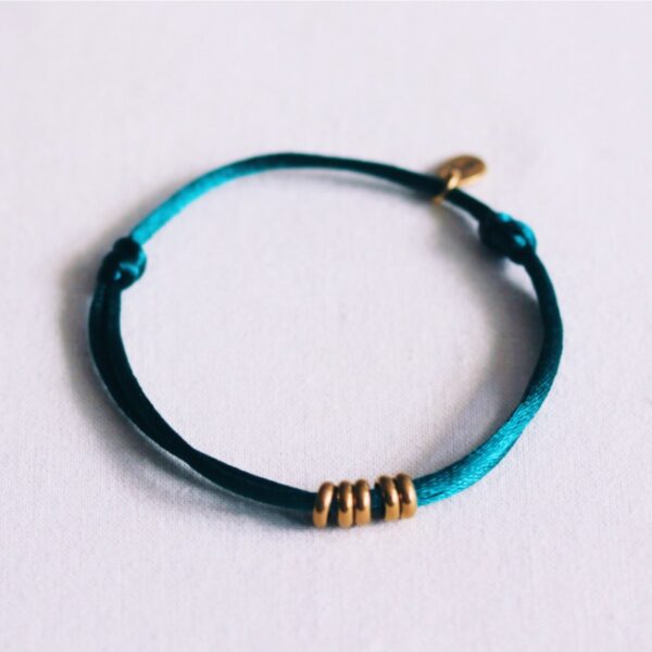 Satijnen armband met ringen in smaragd en goud